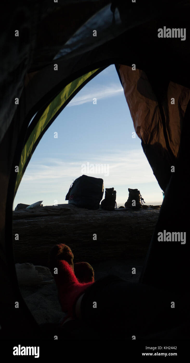 Typische camping Szene aus dem Inneren der Hütte Perspektive: nassen Boot & Trocknen in der Sonne auf ein Protokoll (West Coast Trail, Vancouver Island, BC, Kanada) Stockfoto