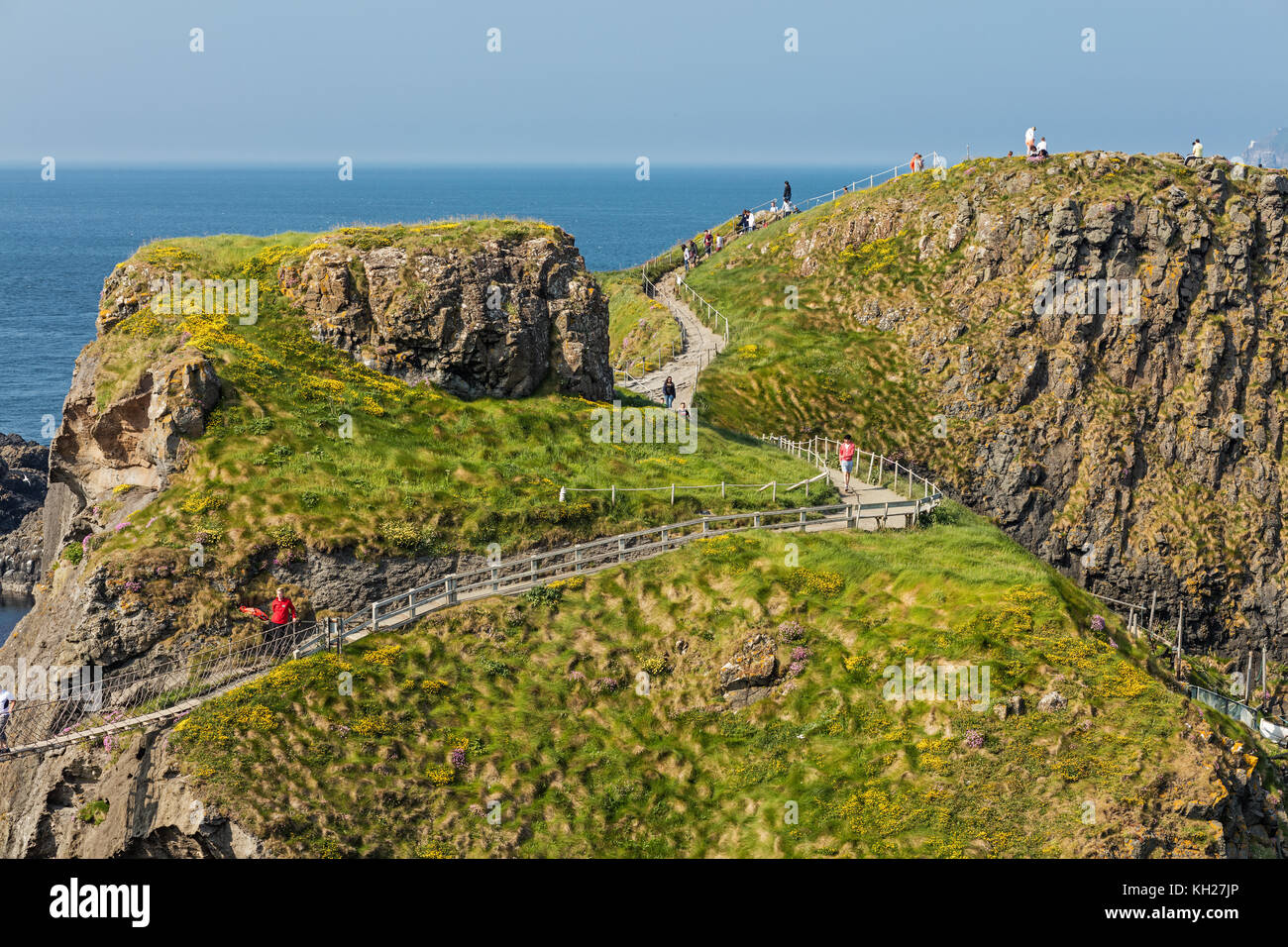 Tausende von Touristen, die Carrick-a-rede rope bridge in County Antrim in Nordirland, hängende 30 m über Felsen und Spanning 20 m, Anbindung des wichtigsten Stockfoto