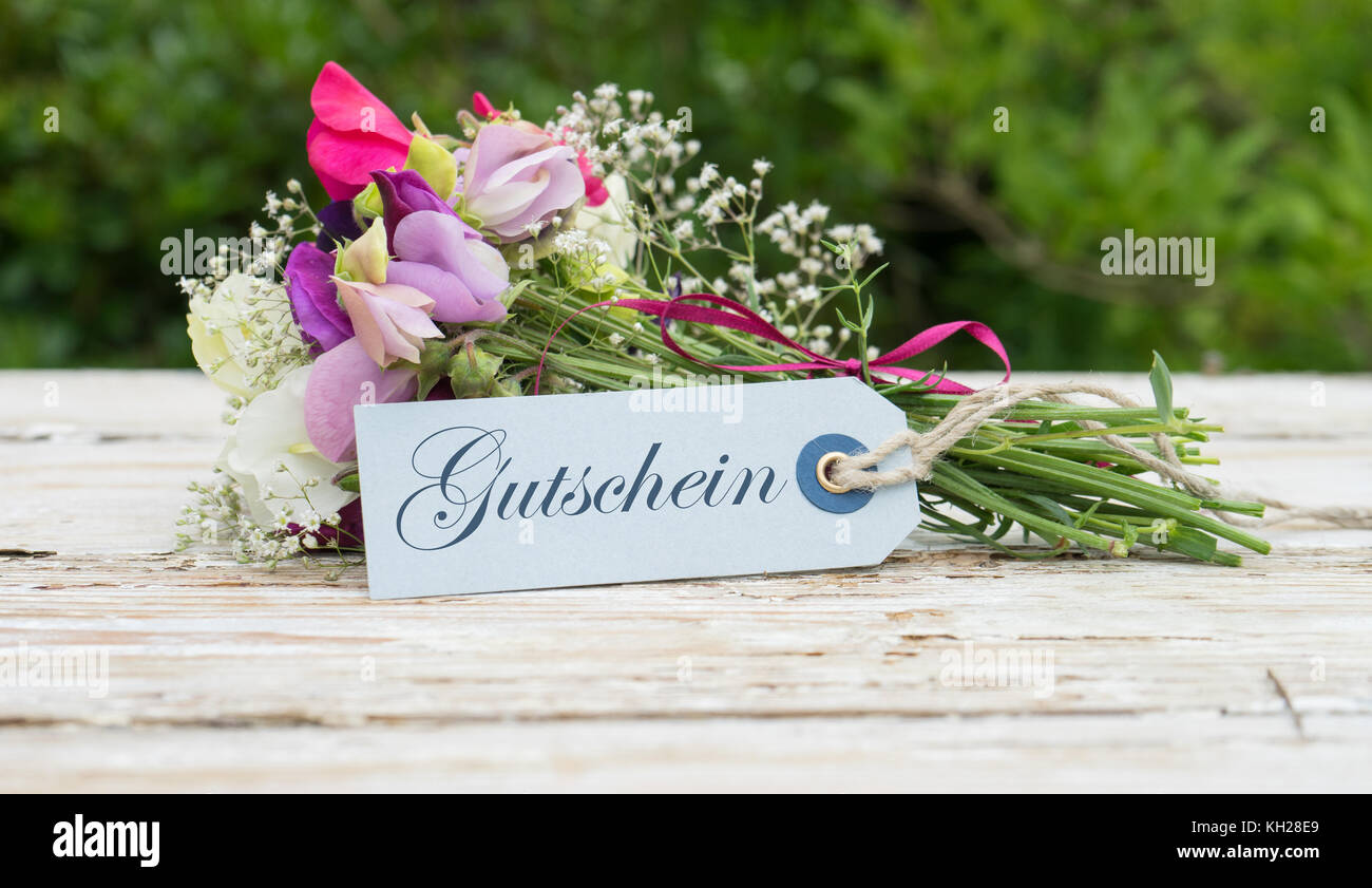 Blumenstrauß mit duftenden Wicken und Grußkarten mit deutschen Text: Geschenkkarte Stockfoto