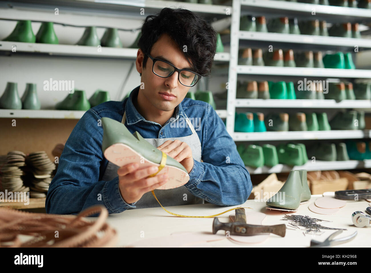 Junge Schuster Schuh Messen mit Arbeitsplatz im eigenen Studio Stockfoto