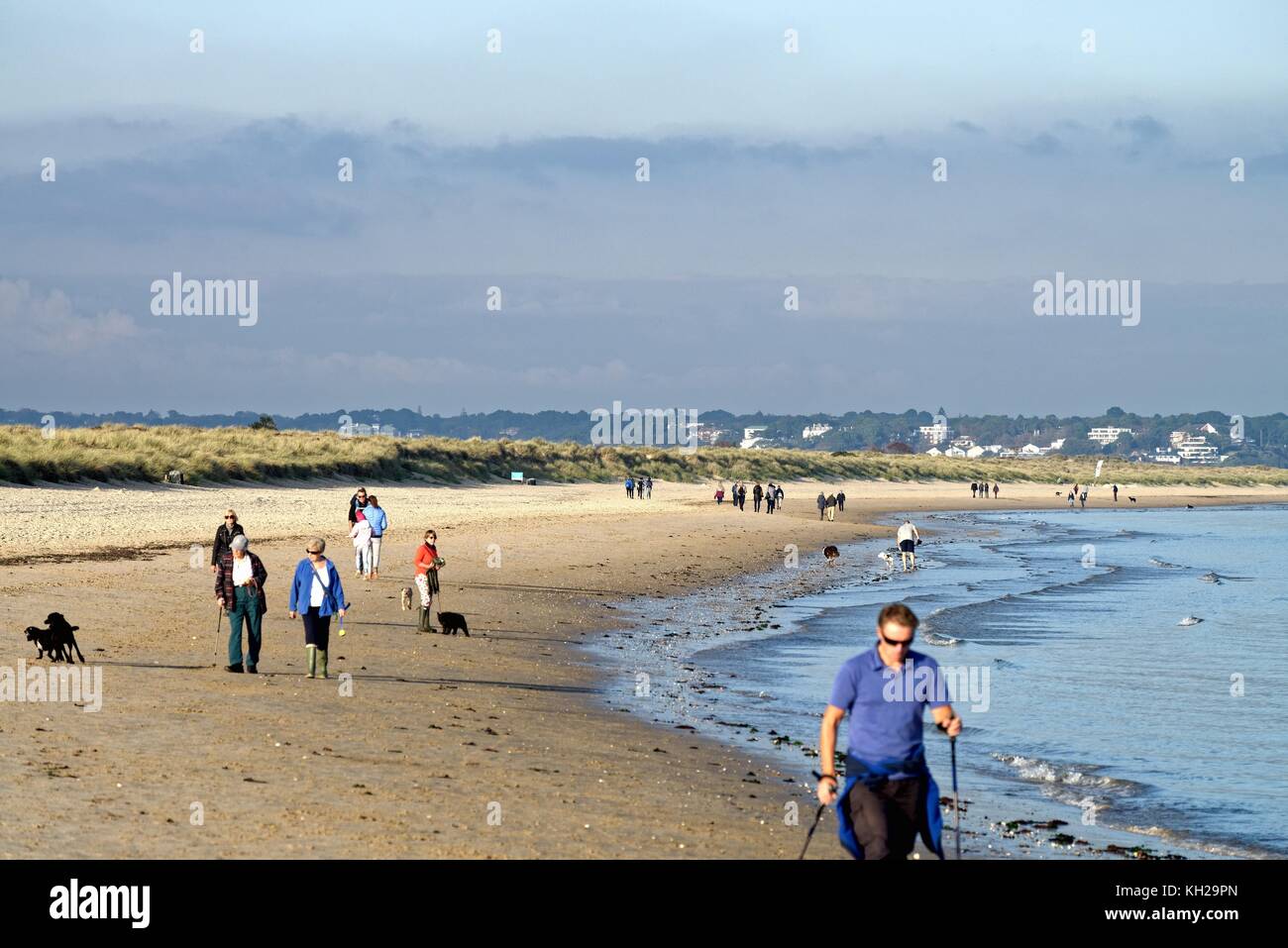 Menschen zu Fuß auf Studland Bay Strand im Herbst Sonne Dorset England uk Stockfoto