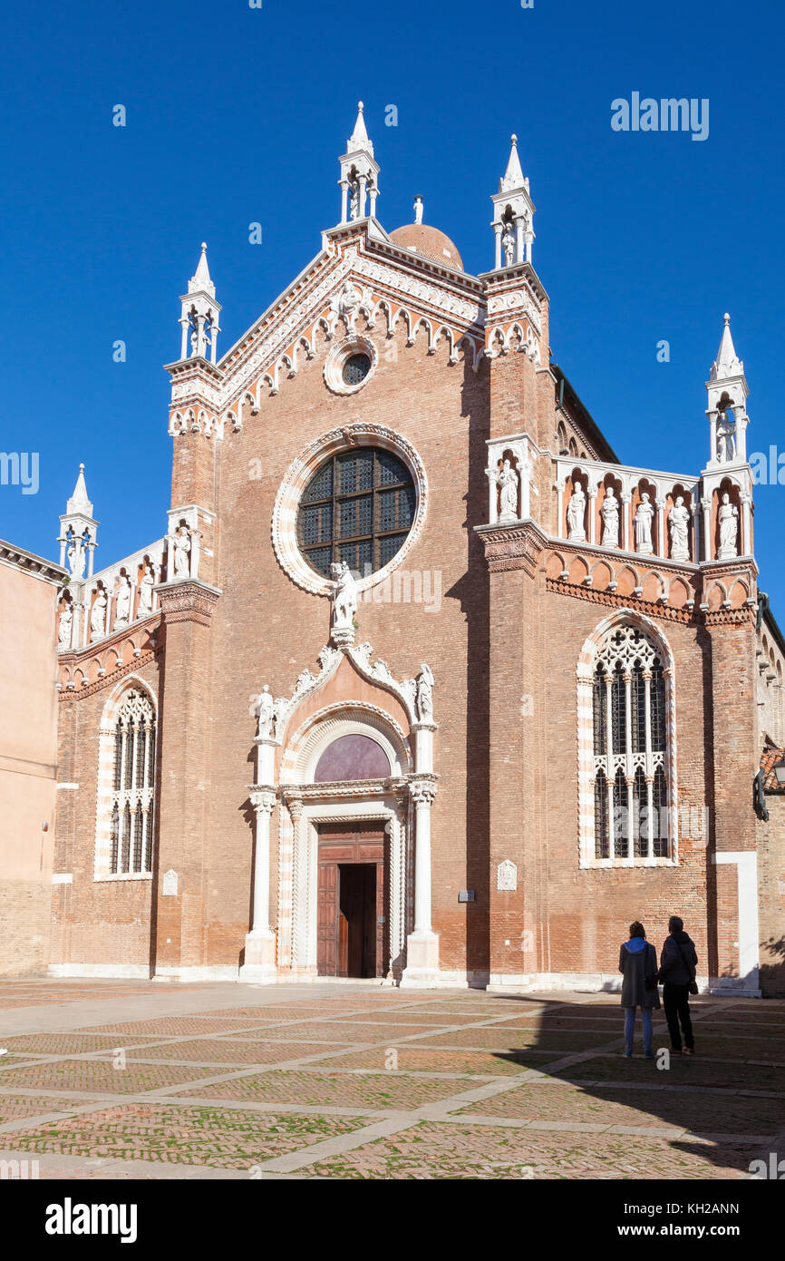 Zwei Touristen stehend admiriong die gotische Fassade der Kirche Madonna dell'Orto, Cannaregio, Venice, Italien, ist die Ruhestätte oder Tintore Stockfoto