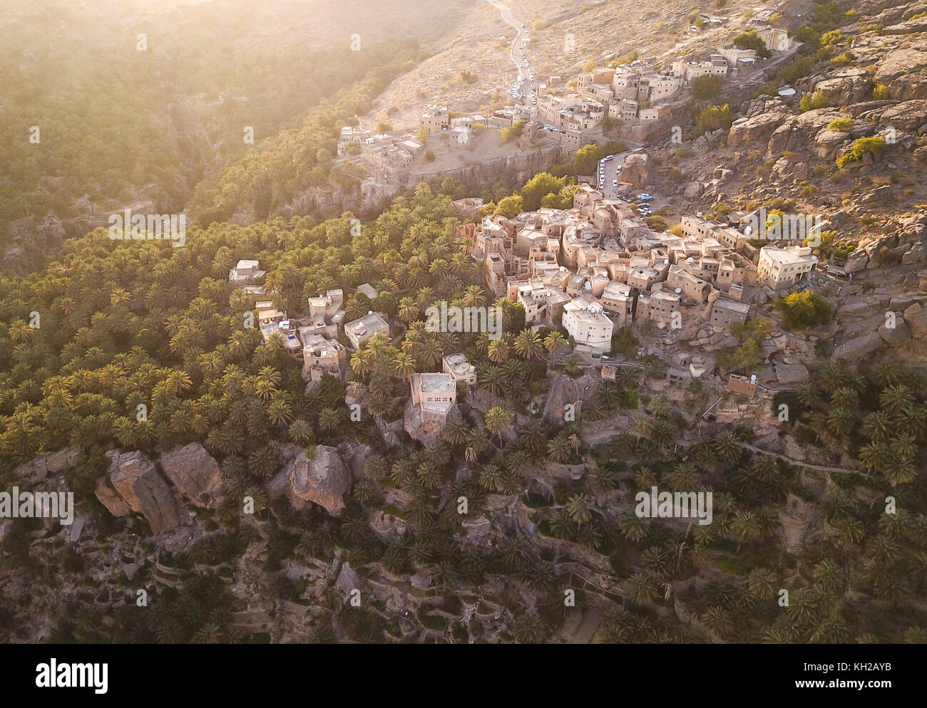 Antenne drone Ansicht einer alten traditionellen omanischen Schlamm Dorf in den Bergen unter Datum Palmen. Misfat Al Aberyeen, Oman. Stockfoto