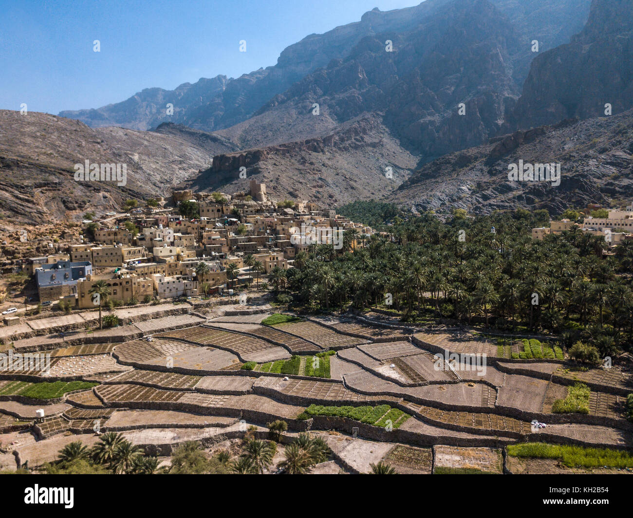 Antenne drone Ansicht einer alten traditionellen omanischen Schlamm Dorf in den Bergen unter Datum Palmen. Balad Seet, Oman. Stockfoto