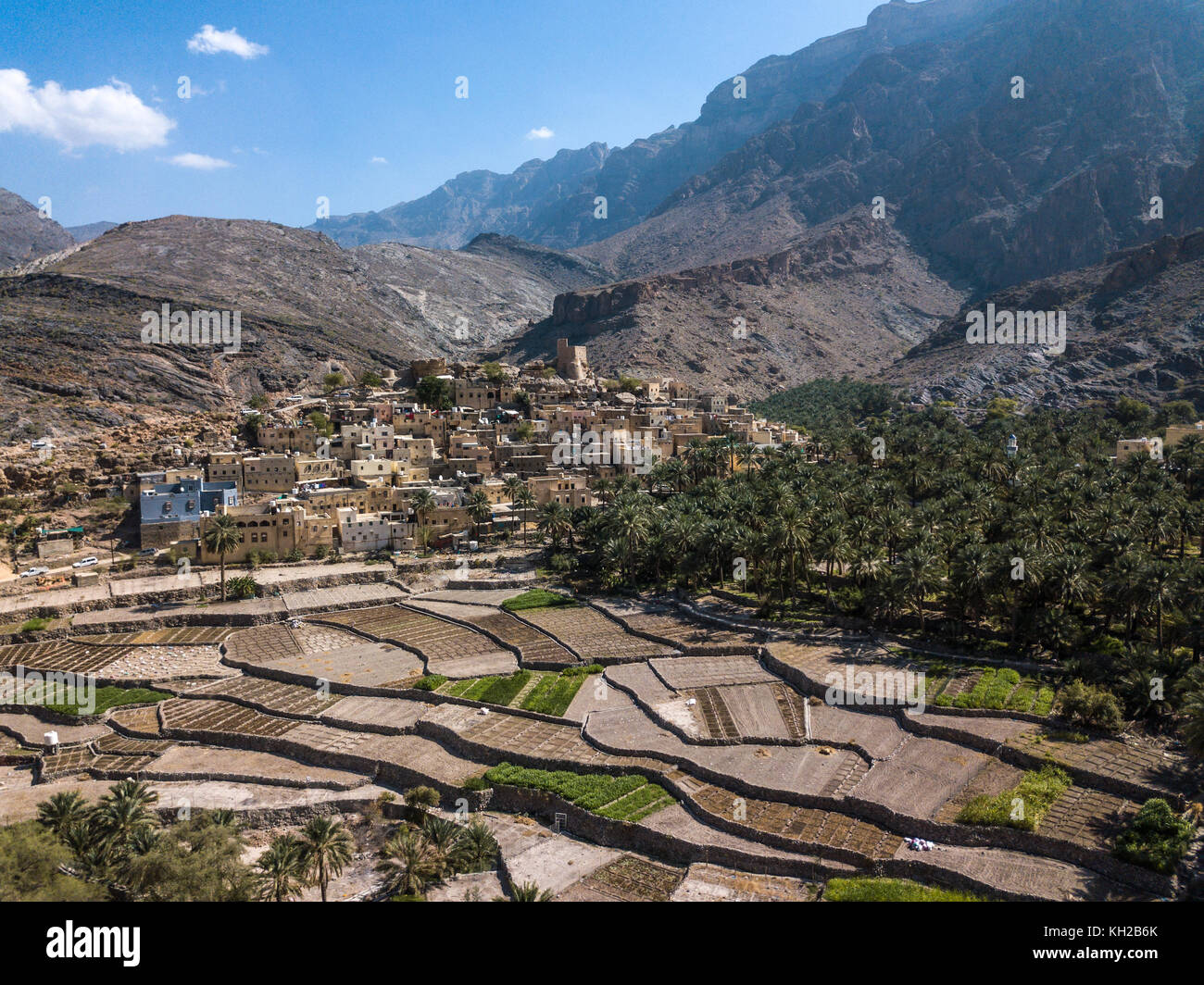 Antenne drone Ansicht einer alten traditionellen omanischen Schlamm Dorf in den Bergen unter Datum Palmen. Balad Seet, Oman. Stockfoto