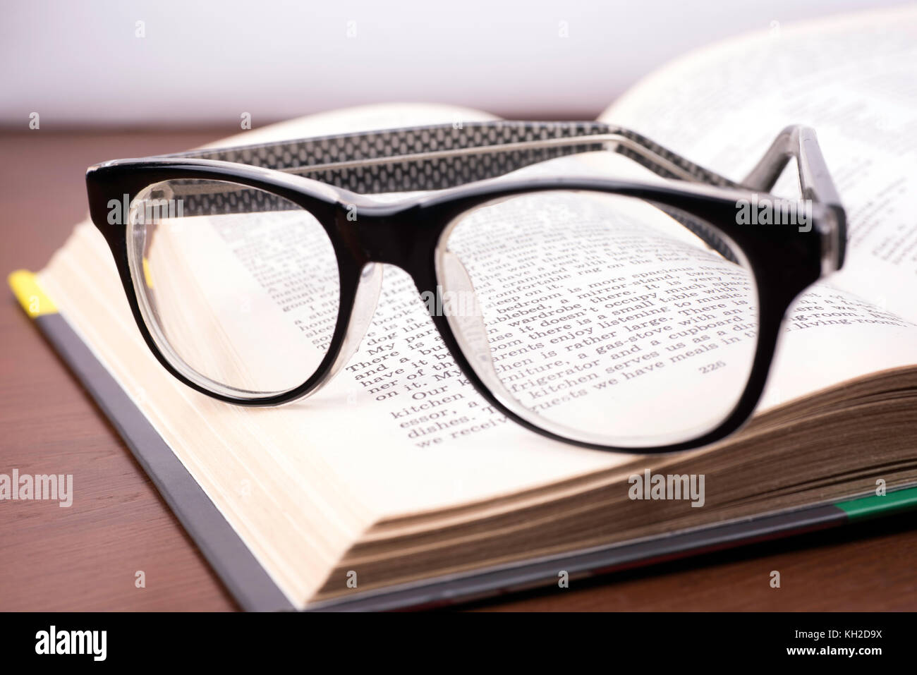 Schauen Sie durch die Brille an einem Buch über die englische Sprache Stockfoto