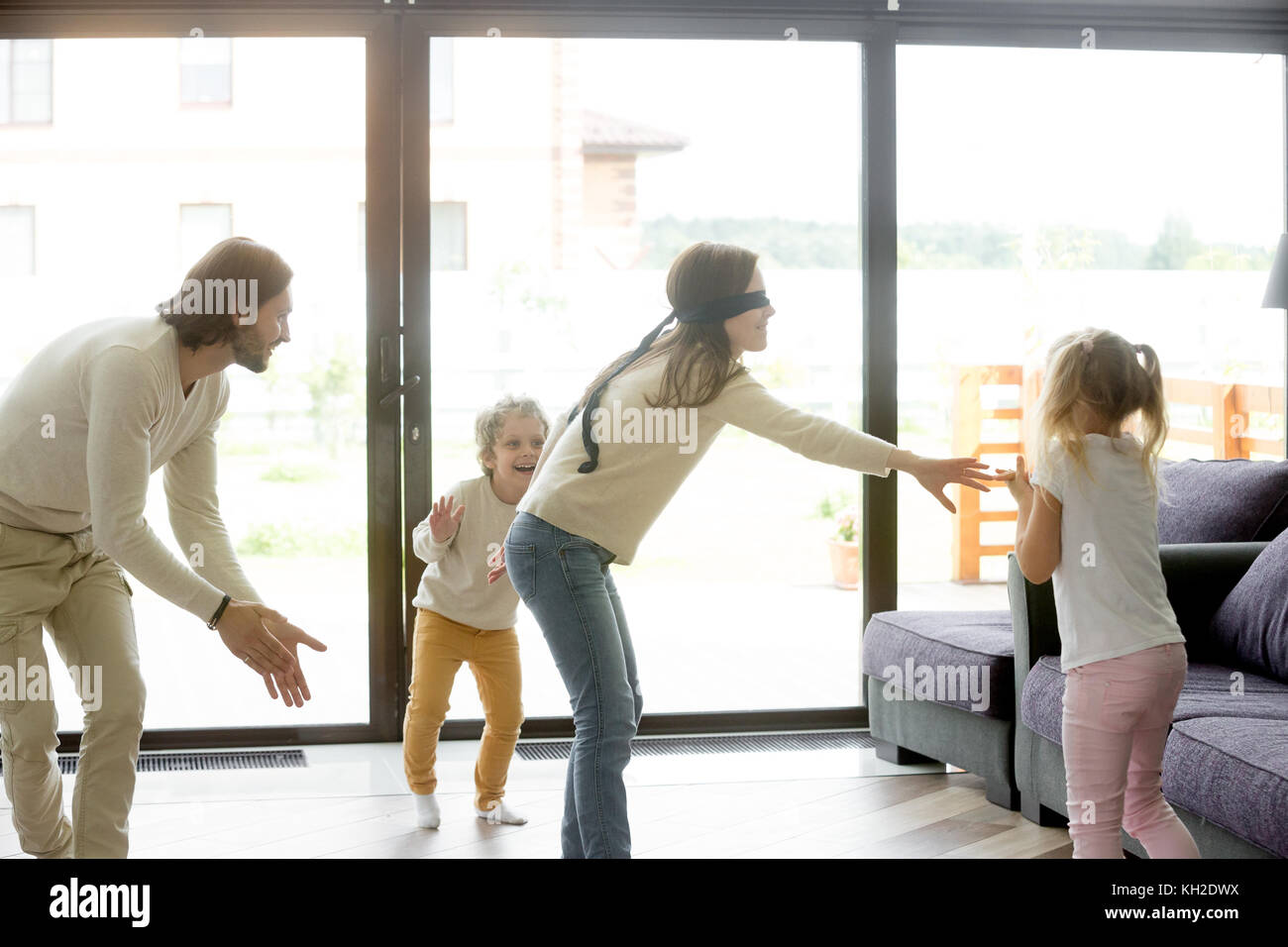 Mit verbundenen Augen Mutter spielt verstecken und suchen Spiel mit Vater und Kinder ausblenden Händeklatschen zu Hause, glückliche Familie Spaß zusammen auf Freizeitaktivitäten in Livin Stockfoto