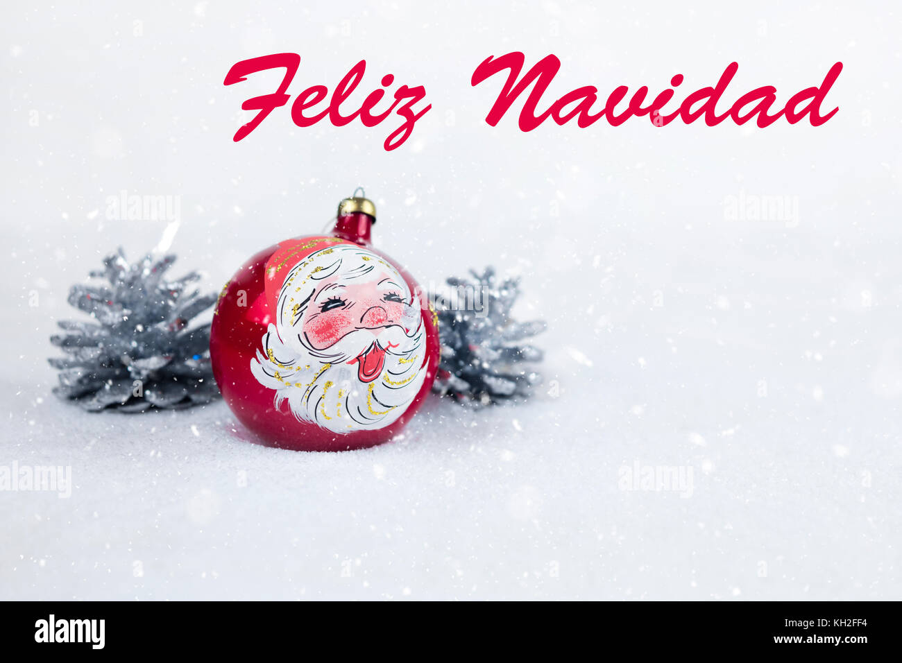 Gruppe von farbigen christmas ball mit Zeichnung von Santa Claus und Kiefern mit Text in Spanisch "Feliz Navidad" im weißen Schnee Hintergrund. Stockfoto