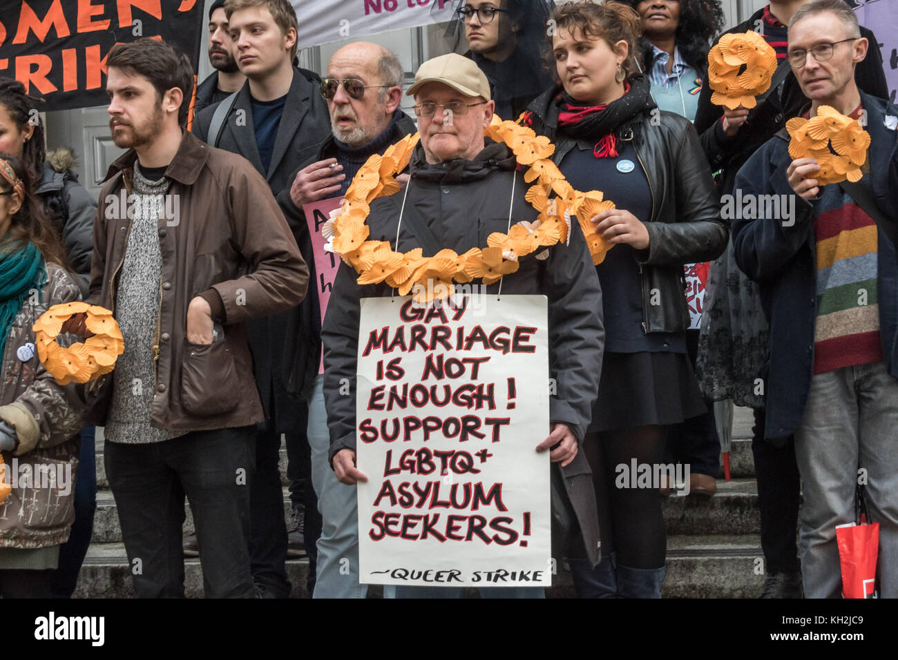 November 11, 2017 - London, UK. 11. November 2017. Die Menschen einige tragende Rosa gaze Schleier und Holding Kränze von orange Mohn machen Sie sich bereit, an der Prozession von Lesben und Schwule organisiert bis März unterstützen die Migranten das Leben-ring Kränze in Gedenken an die Menschen, die gestorben sind, ihren Krieg zerrissenen Ländern fliehen Zuflucht in den letzten Jahr am Ehrenmal zu suchen. Viele von denen, die Waren entweder Flüchtlinge oder diejenigen, die sich aktiv an ihnen Unterstützung beteiligt gewesen sind, sowohl in den Lagern von Calais und auf griechischen Inseln. Nach den Ausführungen auf den Stufen des Bundesministeriums der Verteidigung sie Ho verarbeitet Stockfoto