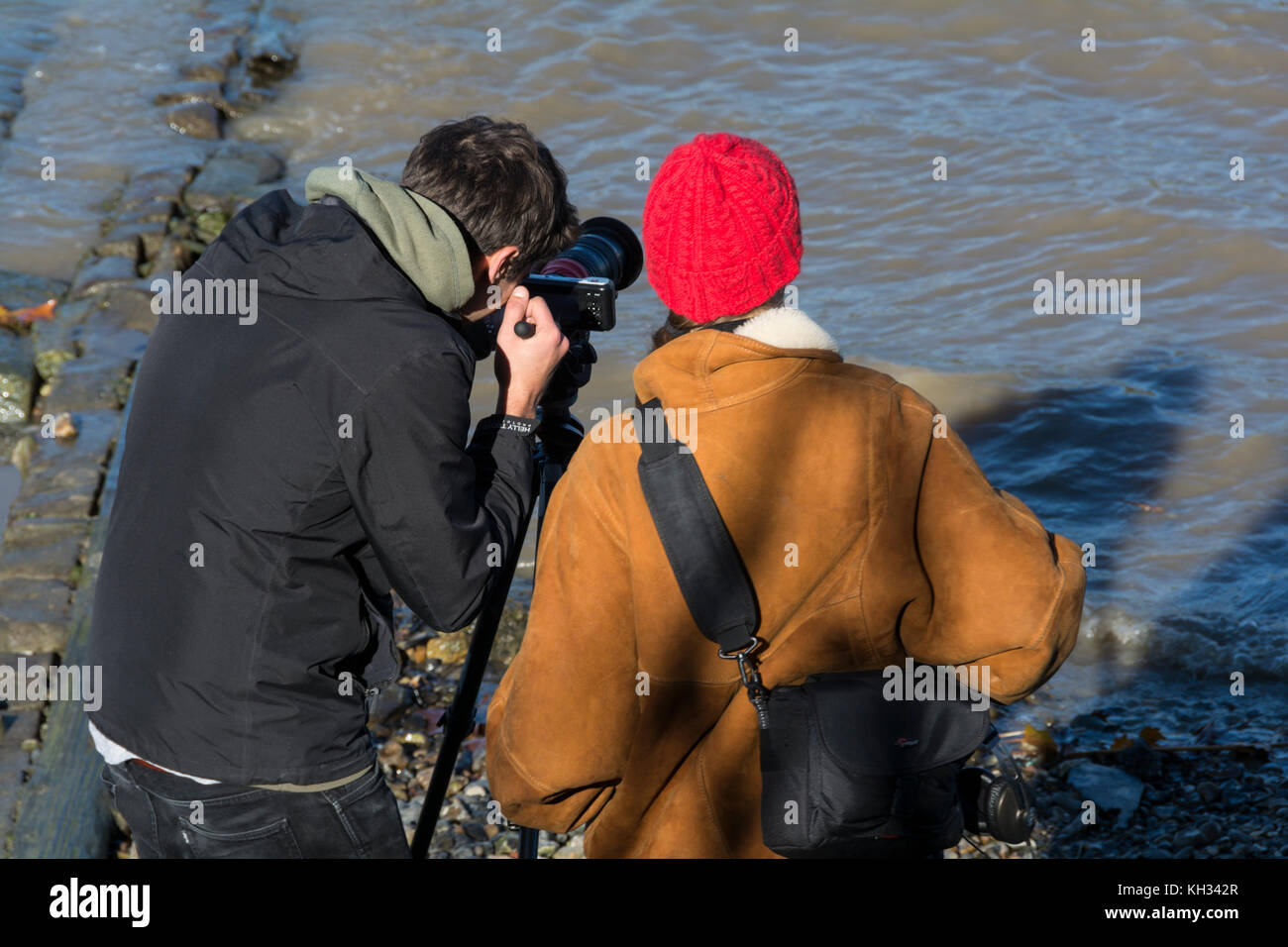 Zwei junge Fotografen in lebhaftes Gespräch auf der Themse Vorland, London, UK. Stockfoto