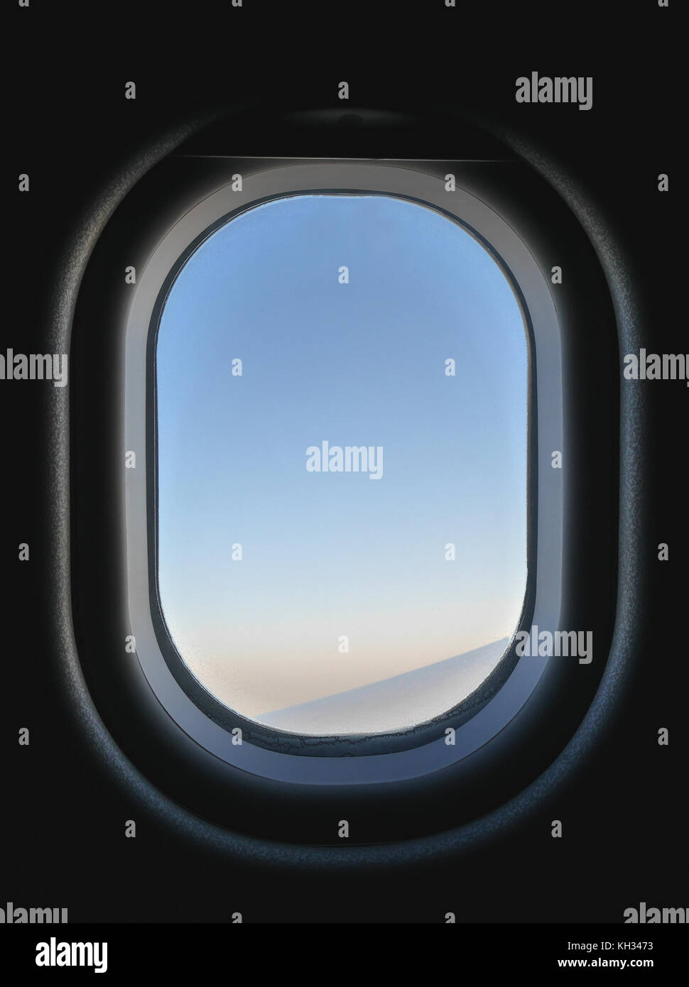 Gefrorene Flugzeug Fenster Blick von Innen, blau und rosa Himmel und Teil des Flugzeugflügel. Im Flugzeug ist dunkel, aber außerhalb ist hell während Stockfoto