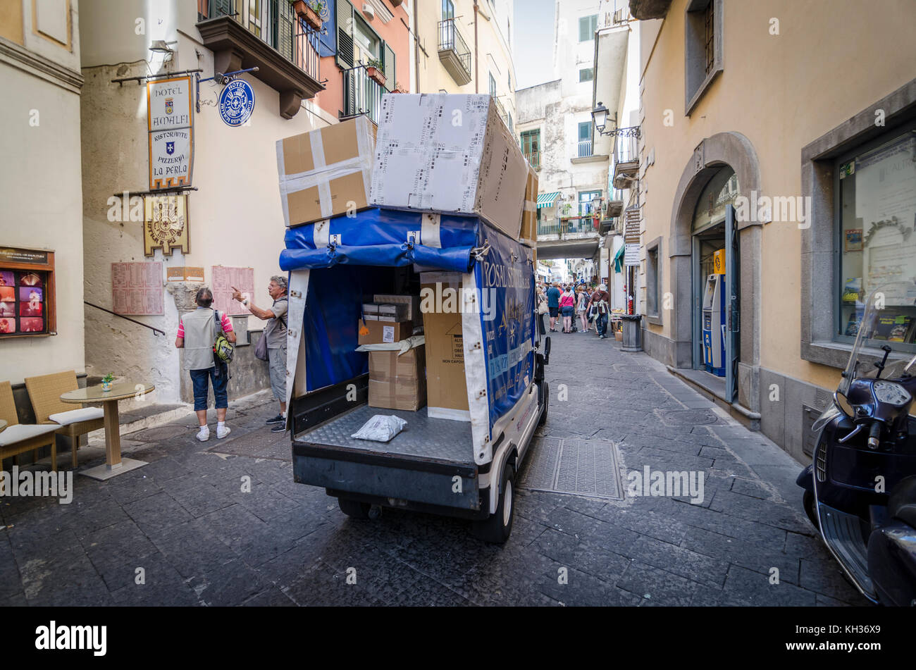 Kleine Elektrofahrzeug EV liefern Pakete durch die engen, historischen Gassen der Stadt Amalfi in Italien Stockfoto