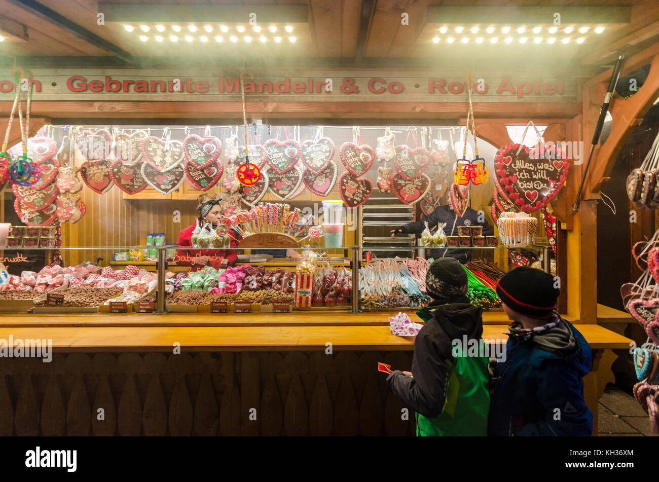 Kinder kaufen Bonbons und Süßigkeiten von einem Deutschen Weihnachtsmarkt Stall, Berlin, Deutschland Stockfoto