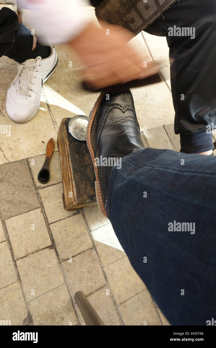 Schuhputzmaschine/-mann, Schuhputzzeug, bei der Arbeit, putzen Schuhe von einem Kunden. Malaga, Andalusien, Spanien. Stockfoto