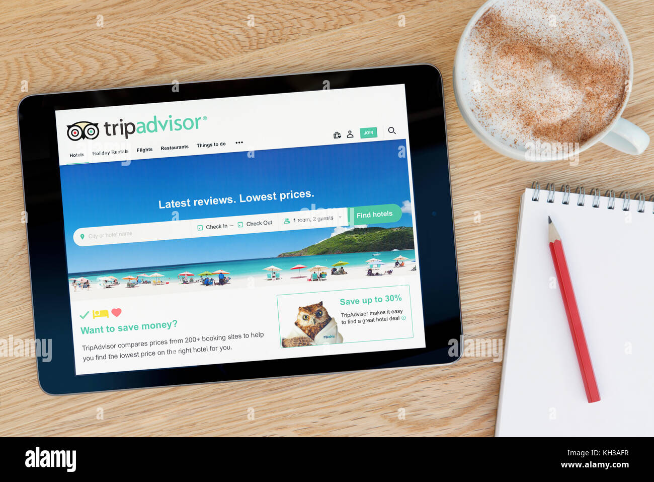 Die Tripadvisor website Funktionen auf einem iPad Tablet Gerät, das auf einem Tisch liegt neben einem Notizblock und Bleistift und eine Tasse Kaffee (redaktionellen) Stockfoto