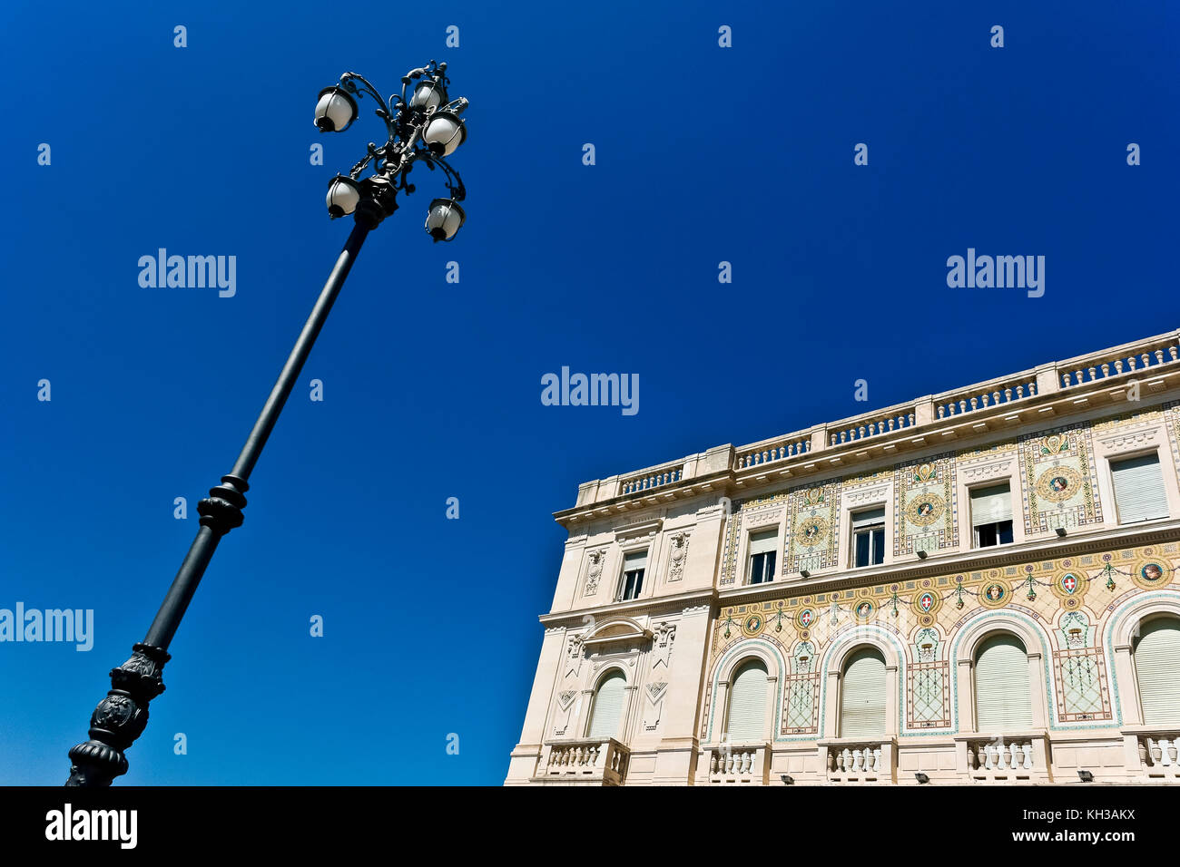 Regierungsgebäude mit Mosaikfassade, Unity Square. Palazzo del Governo, Piazza dell’Unità. Triest, Italien, Europa, EU. Lamppost. Speicherplatz kopieren. Stockfoto