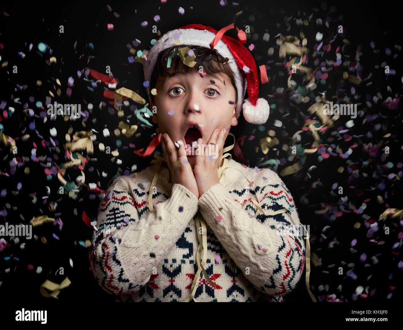 Überrascht Kind in Silvester auf schwarzem Hintergrund Stockfoto