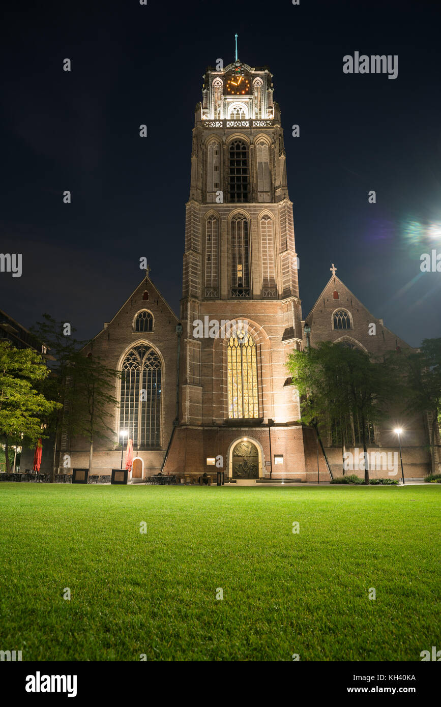 Gotische St. Lorenz Kirche kontrastiert mit hellen grünen Rasen in der Nacht lange Belichtung und Lens Flare von rechts Straße Licht Stockfoto