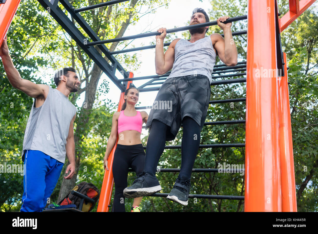 Starker junger Mann tun Chin-up Wiederholungen während Calisthenics w Stockfoto