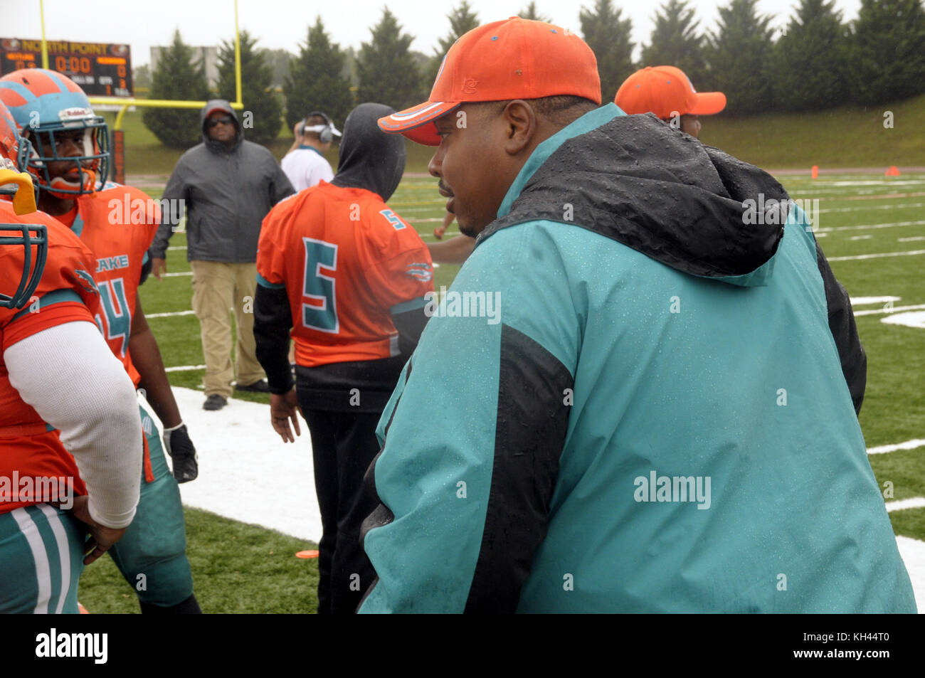 Coach im Gespräch mit dem Spieler in einem High School Fußballspiel Stockfoto