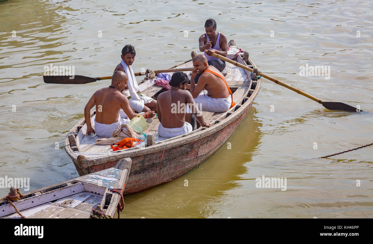 Priester auf einem hölzernen Boot auf dem Ganges für die Durchführung bestimmter hinduistischer Rituale im Rahmen einer täglichen Gottesdienstroutine in Varanasi Indien. Stockfoto