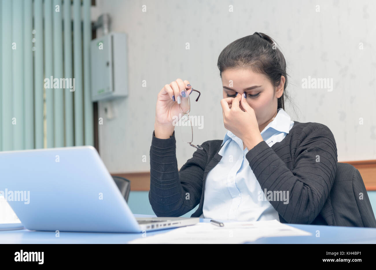 Asiatische Frau bekam Kopfschmerzen vom Arbeiten am Notebook den ganzen Tag lang, Computer Vision Syndrom Stockfoto