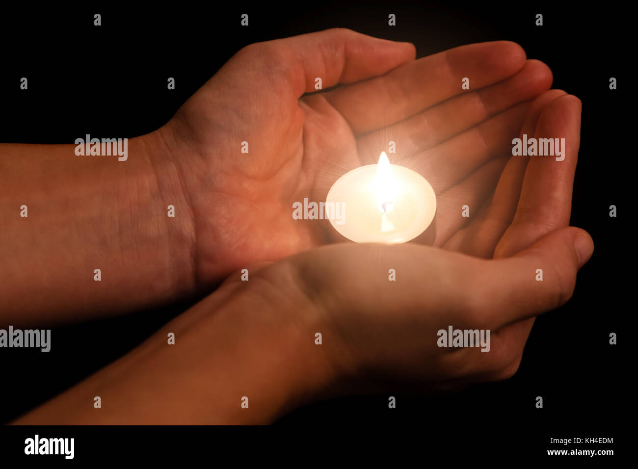 Hände halten und Schützen von Leuchten oder brennende Kerze Kerzenlicht auf Dunkelheit. schwarzer Hintergrund. Konzept für Gebet, Beten, hoffen, Vigil, Night Watch Stockfoto