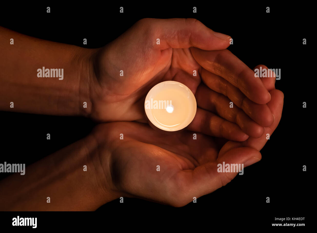 Hände halten und Schützen von Leuchten oder brennende Kerze Kerzenlicht auf Dunkelheit. schwarzer Hintergrund. Konzept für Gebet, Beten, hoffen, Vigil, Night Watch Stockfoto