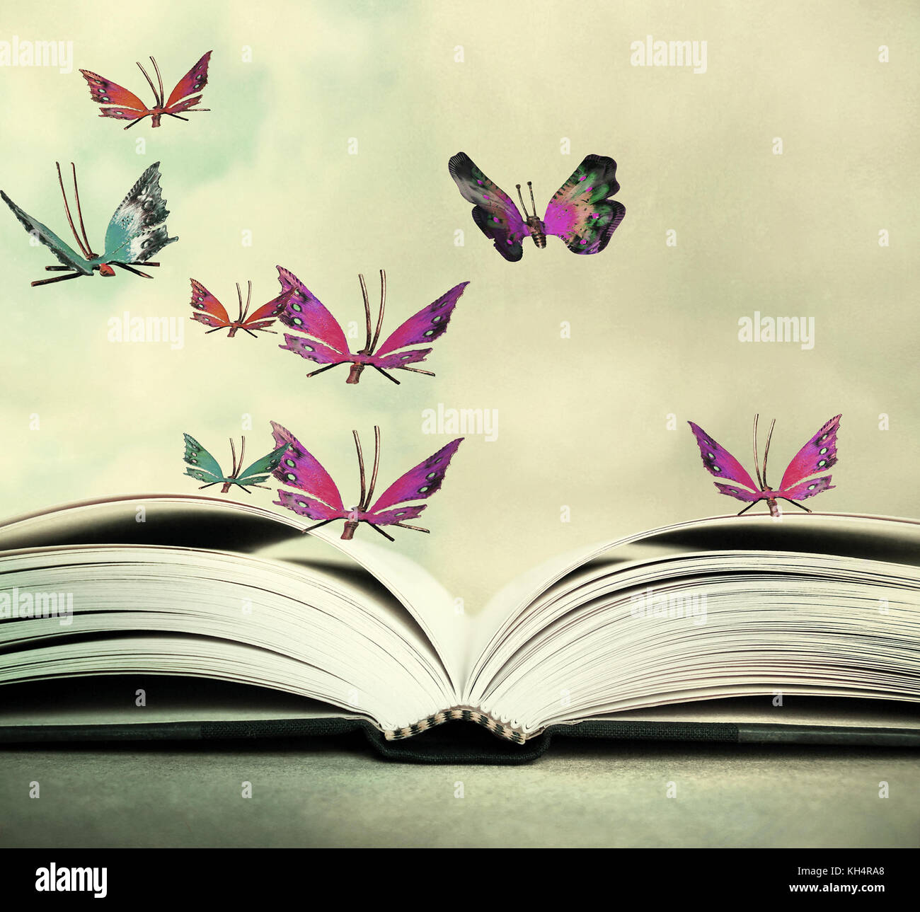 Künstlerische Bild von einem offenen Buch und bunte Schmetterlinge, die in der Luft schweben Stockfoto