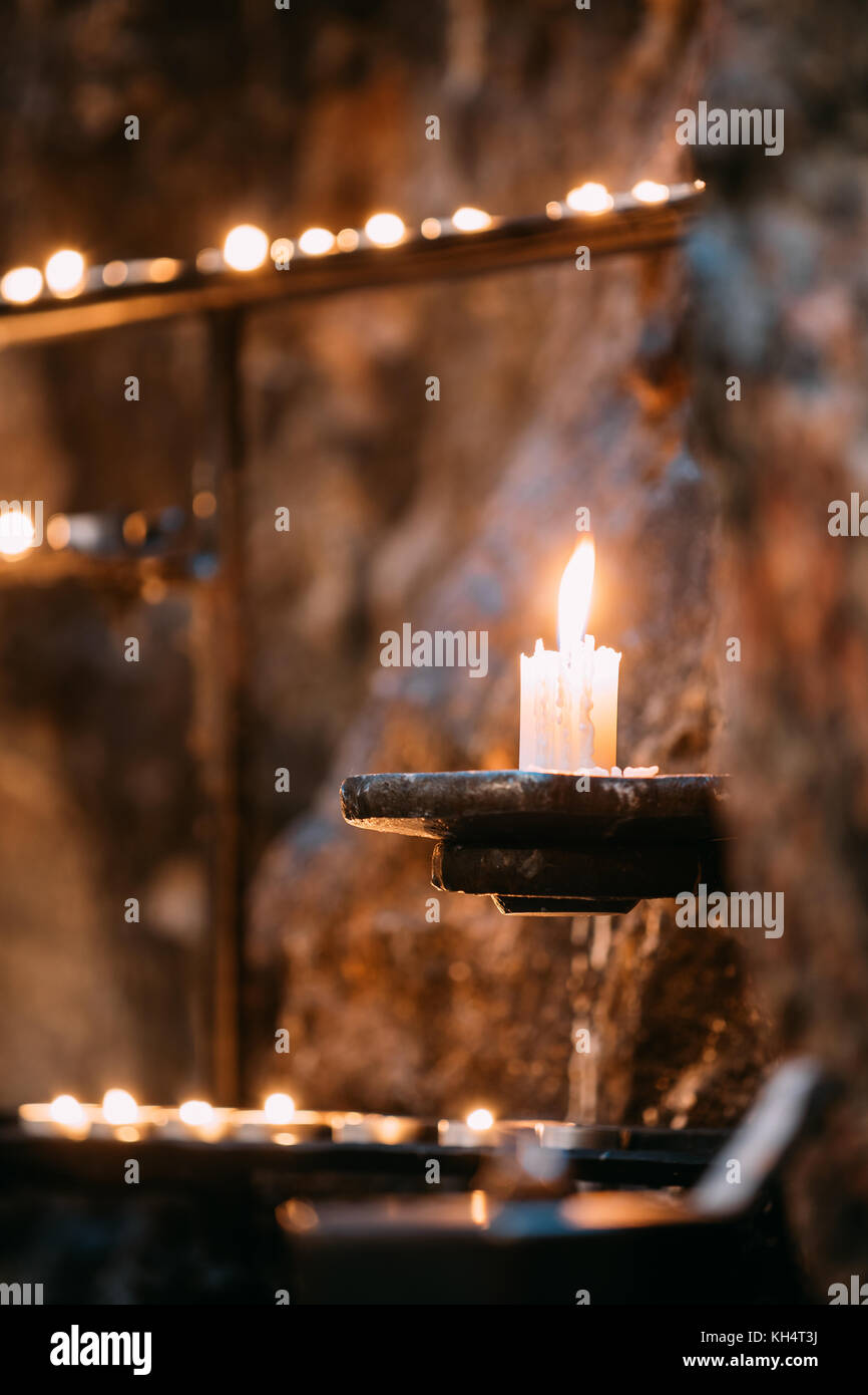 Alte Kerze in der Kirche Kerze Flamme in der Nähe der alten Mauer Stockfotografie