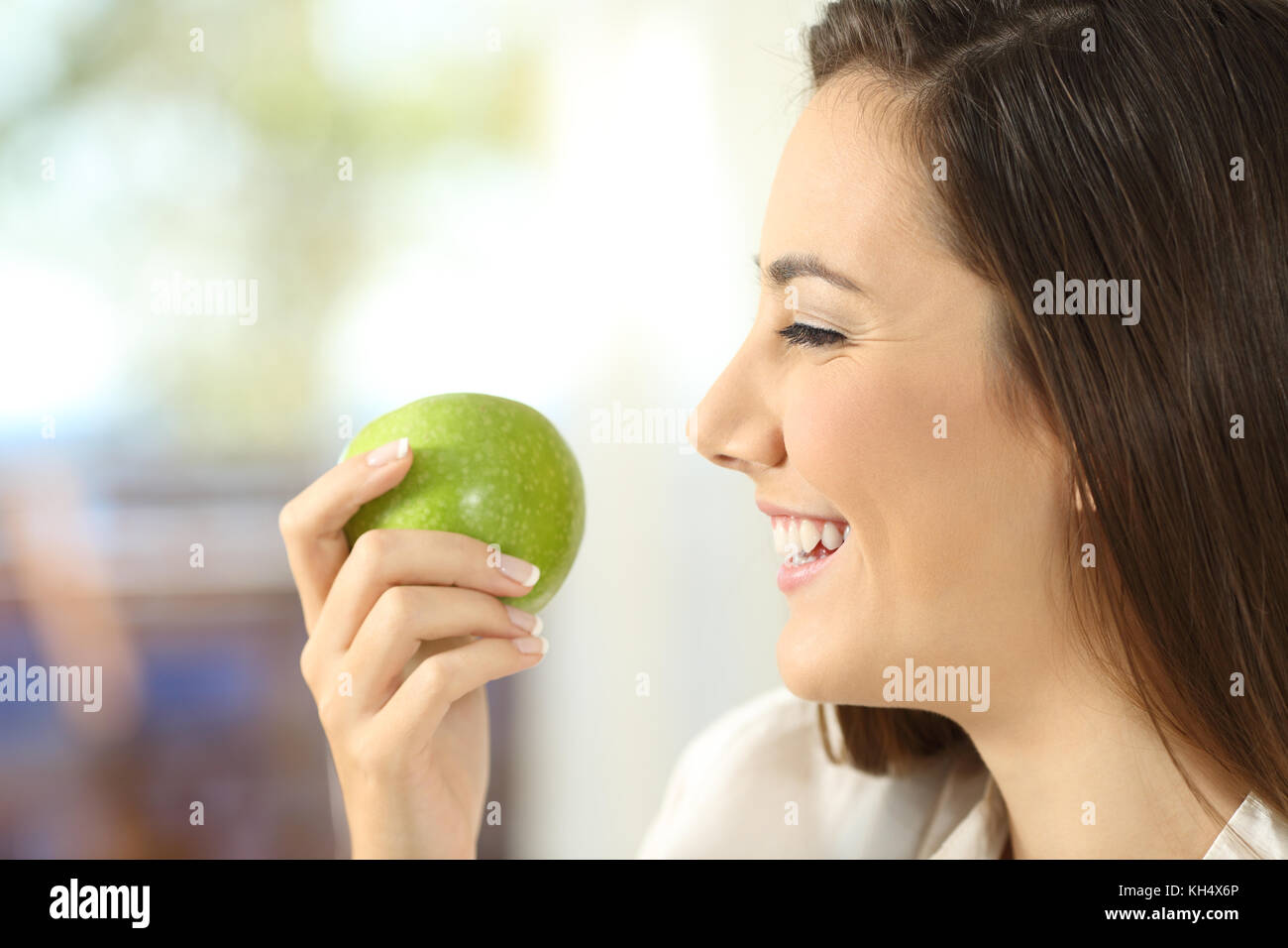 Seitenansicht Portrait einer Frau mit einem Apfel bereit zu Hause essen Stockfoto