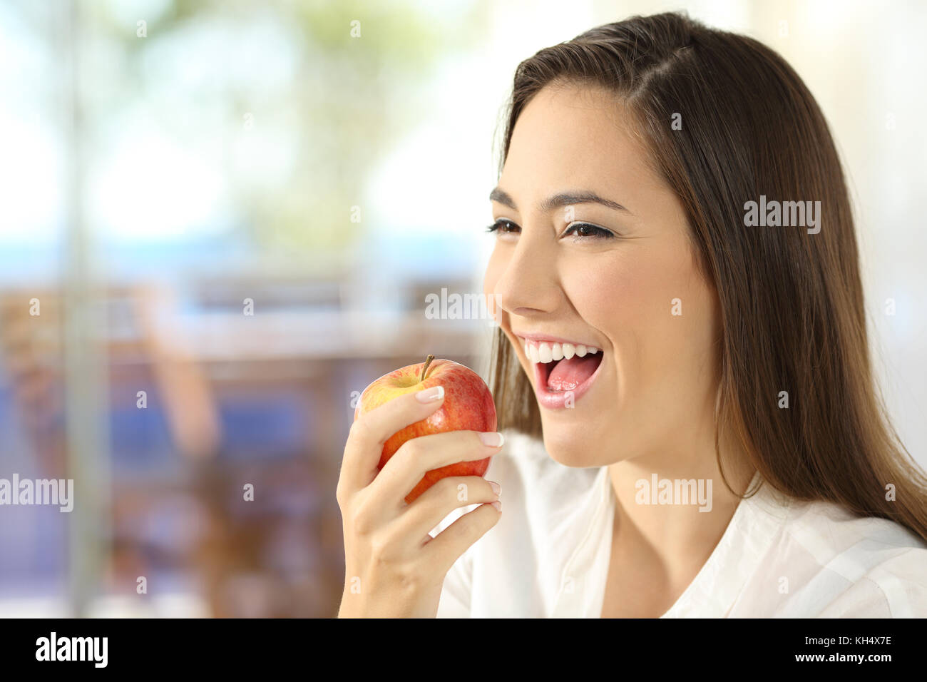Porträt einer Frau isst einen Apfel in die Wohnzimmer zu Hause Stockfoto