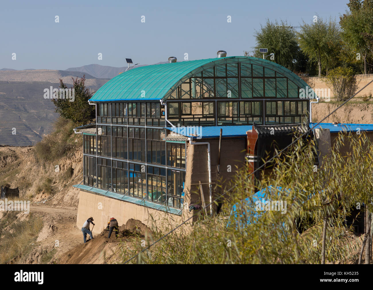 Traditionelle Tibetische Holzhaus mit Glas geschützt die Wärme im Winter zu halten, Tongren County, Rebkong, China Stockfoto