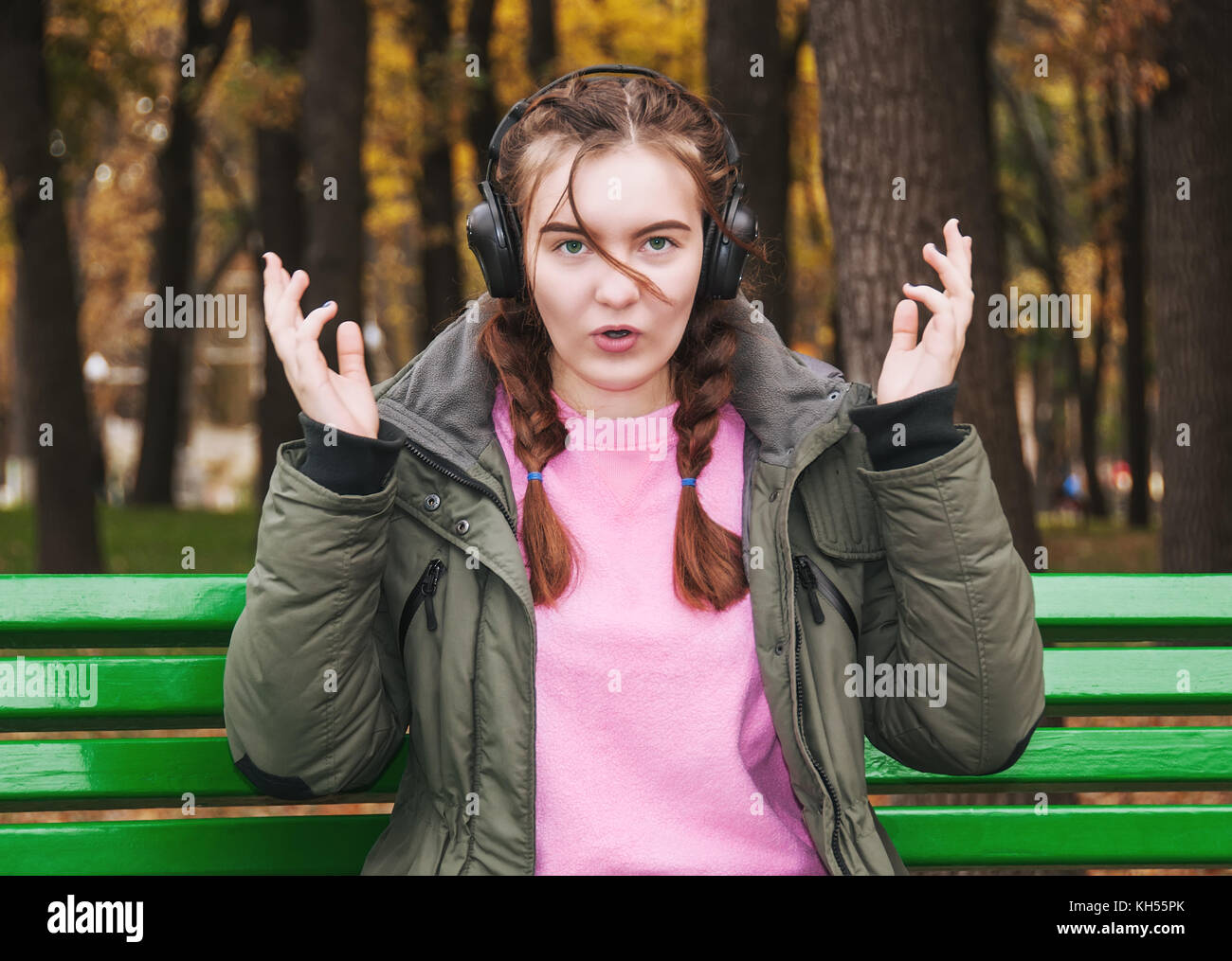 Junges Mädchen mit Kopfhörer überrascht Stockfoto
