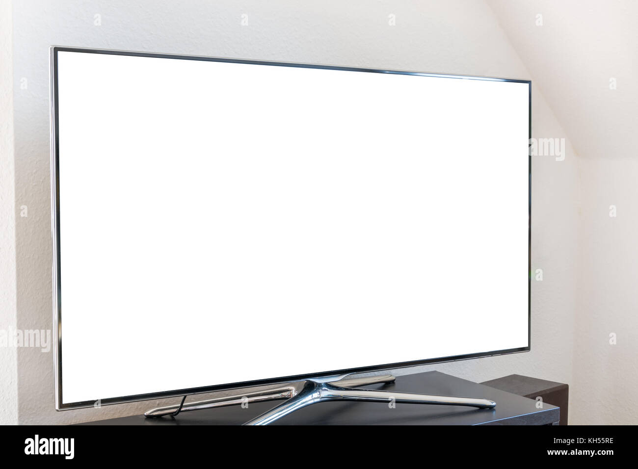 Leere weiße TV-Bildschirm auf einem Stand aus Holz im Wohnzimmer von der Seite Stockfoto