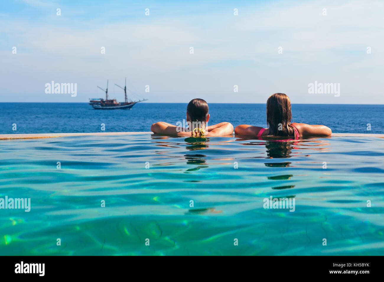 Glückliche junge Frau auf Sommer Strand Urlaub relaxen im Luxus Spa Resort im Infinity-Pool mit Blick auf das Meer. gesunder Lebensstil, Familie reisen zurück Stockfoto