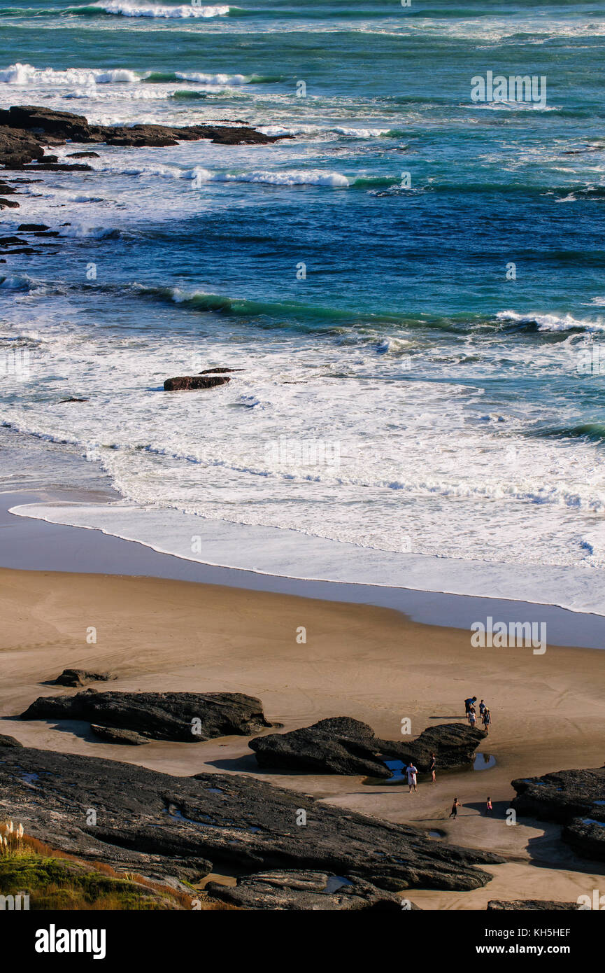 Menschen zu Fuß am Strand mit riesigen Felsen, arai-te-uru Erholung finden südlichen Ende von Hokianga Harbour, Westcoast Northland, North Island, New zealan Stockfoto