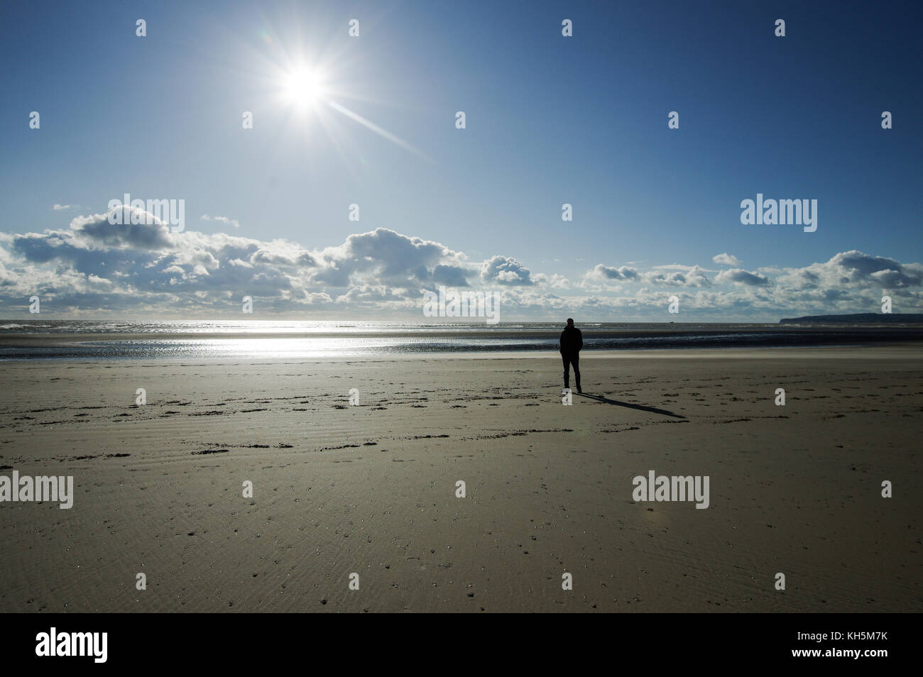 Mann stand auf Camber Sands Beach auf einer scharfen, klaren Herbsttag Stockfoto