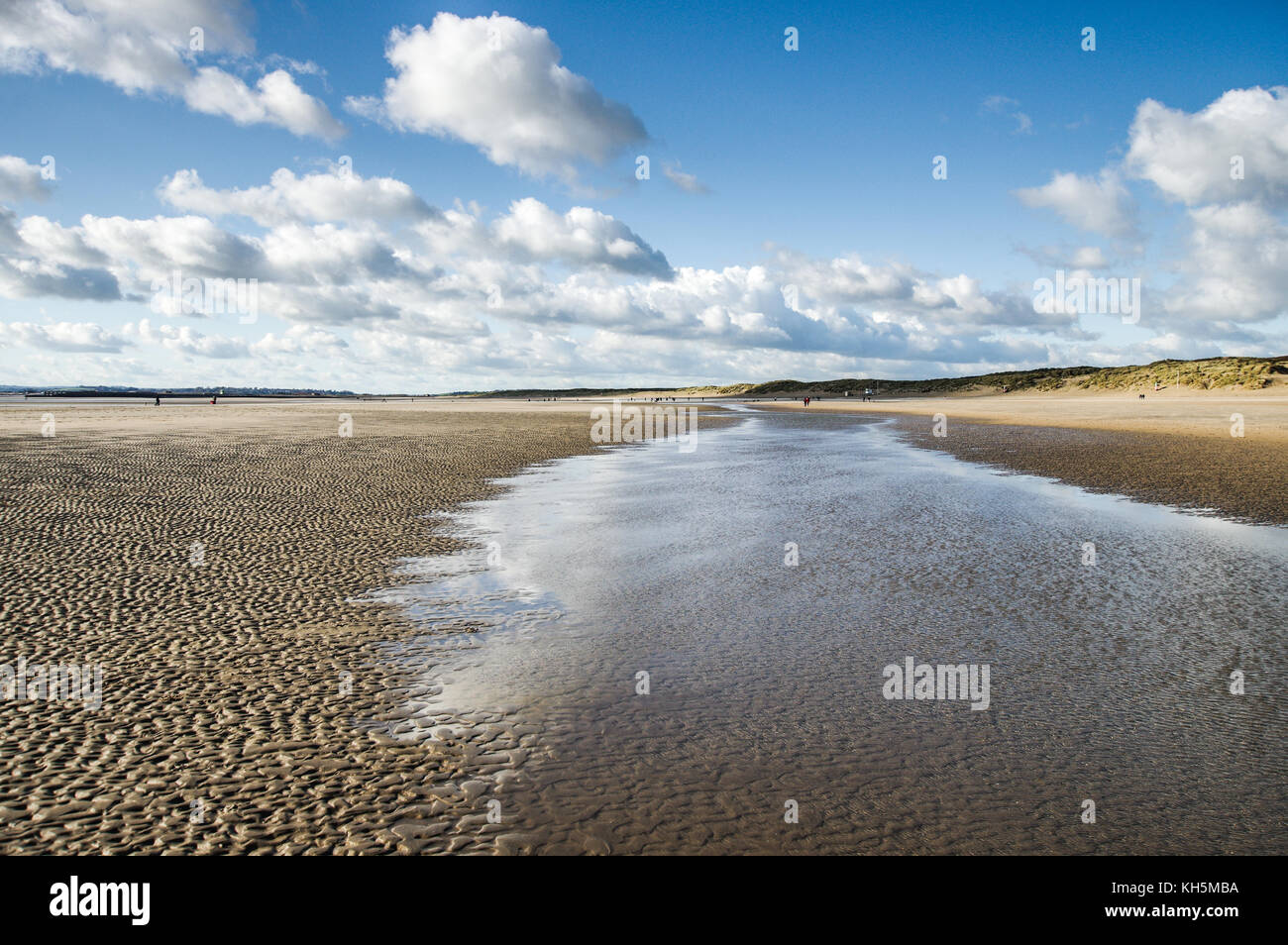 Scharfe herbstlichen Himmel im Wasser stehend auf Camber Sands Beach, die bei Ebbe (East Sussex, England) Stockfoto