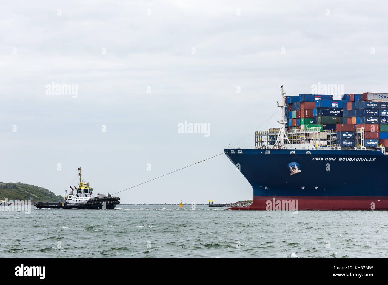 Rotterdam, die Niederlande - Juni 12, 2017: a Tug Boat bringt die extrem großen Containerschiff CMA CGM Bougainville in den Hafen wie es ankommt. Stockfoto