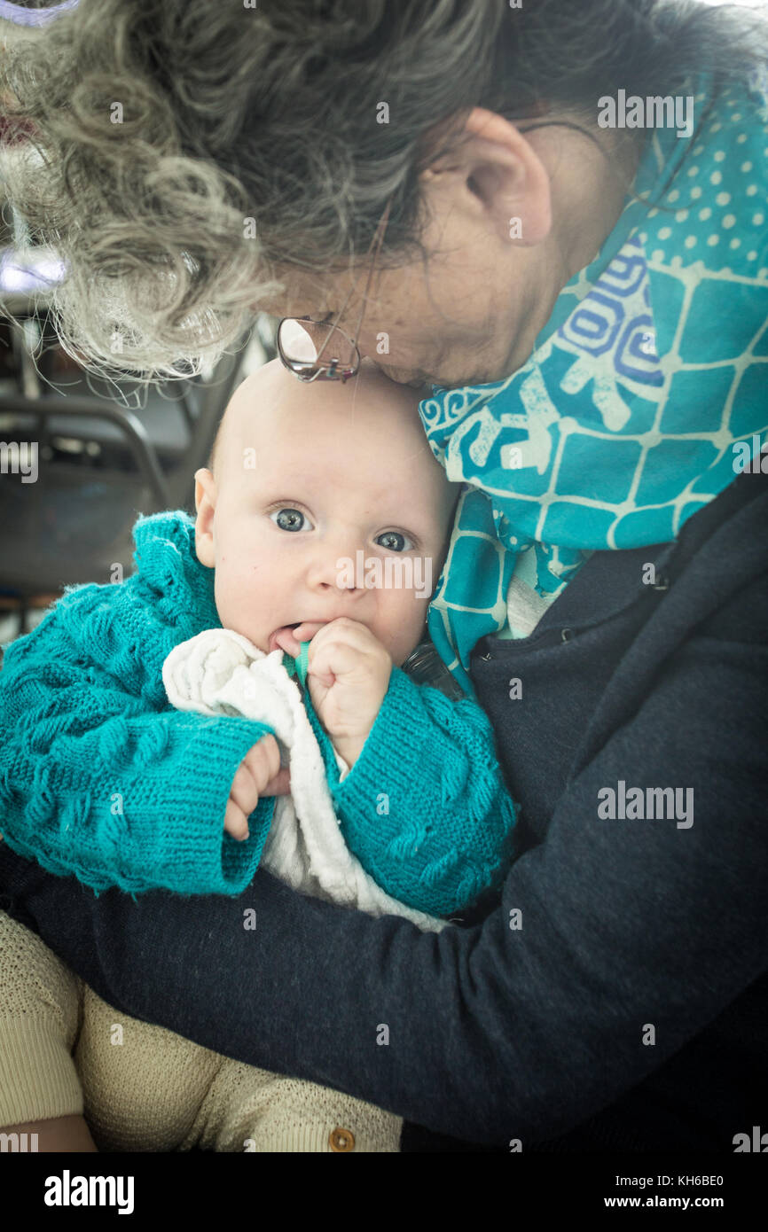 Großmutter halten und küssen grandchildv Stockfoto