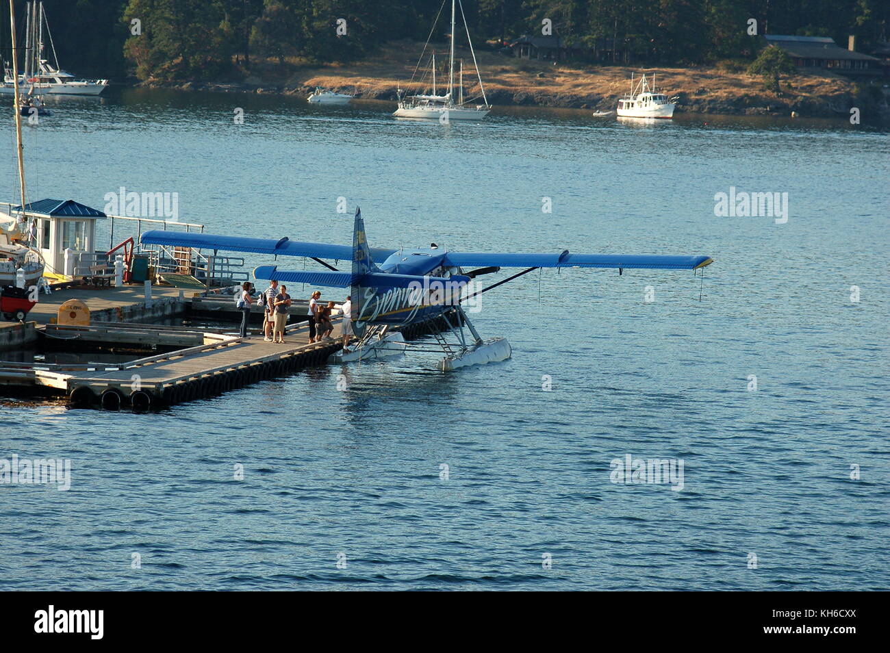 Ein kenmore Air Bayerische Flugzeugwerke Bf DHC-3 Turbine 'Otter' auf Schwimmer, Passagiere laden in Friday Harbor, WA auf dem letzten Flug des Tages. Stockfoto