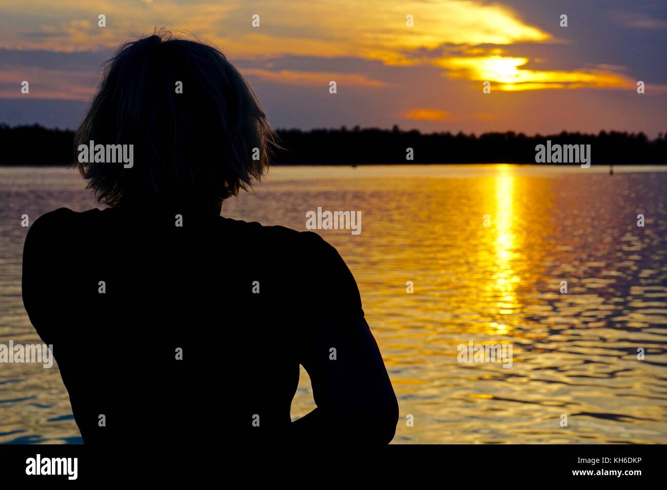 Silhouette Frau Sonnenuntergang am See Stockfoto