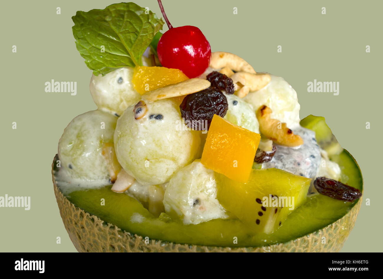 Eis in frischer Melone mit Obstsalat darauf Isoliert auf hellgrünem Hintergrund Stockfoto
