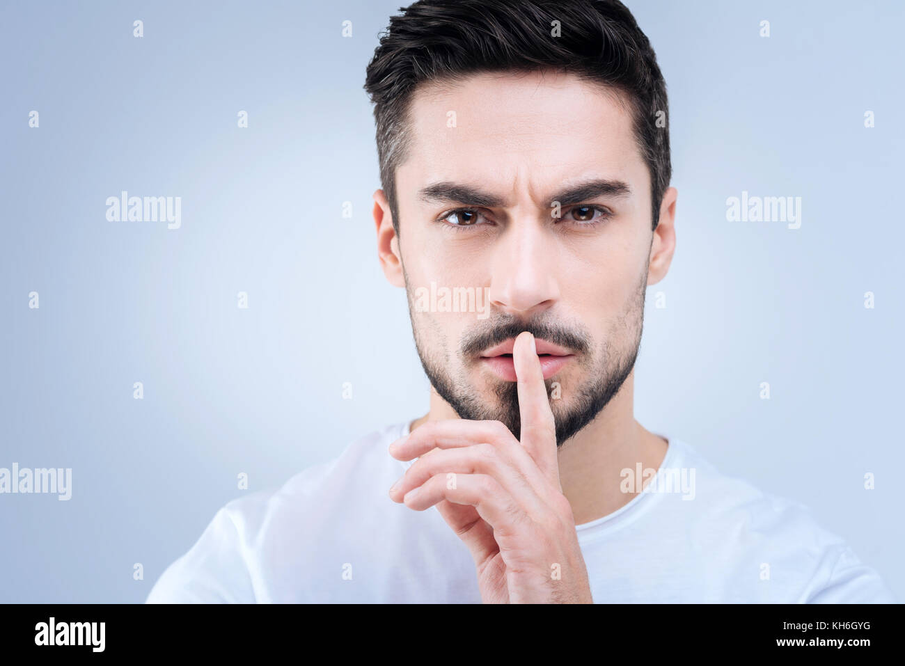 Jungen gutaussehenden Lehrer fragt seine Schüler ruhig zu sein Stockfoto