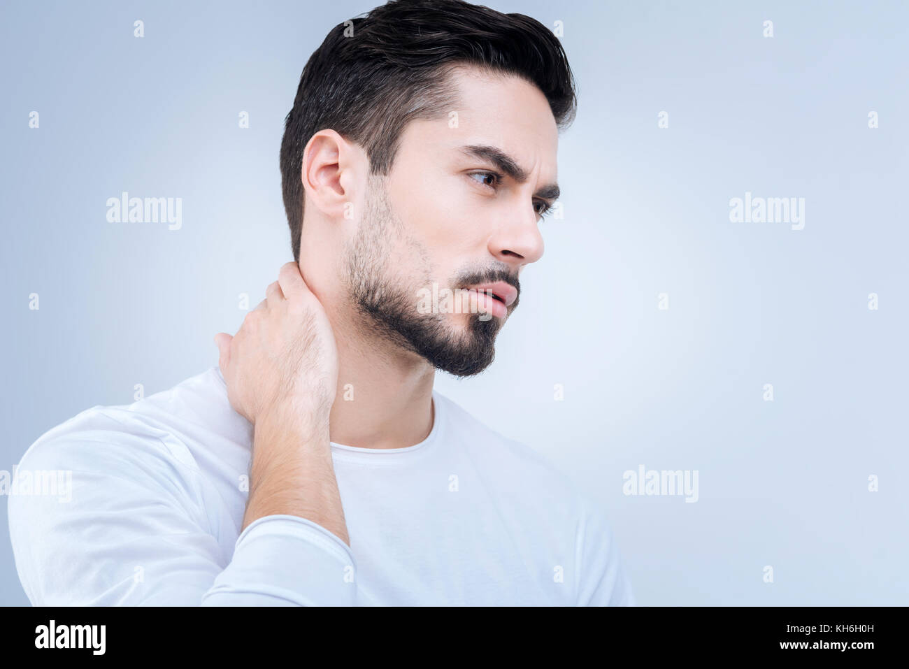 Junger Mann auf der Suche über Schmerzen in seinem Hals sorgen Stockfoto