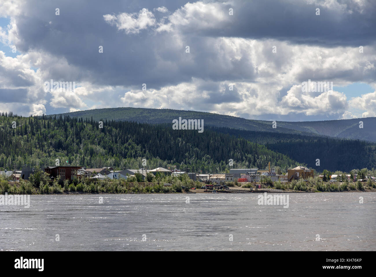 Die kleine 19. Jahrhundert Goldgräberstadt Dawson City ist unter den kleinen Bäumen entlang des Yukon River gesetzt. Eine Fähre Reisende über. Stockfoto