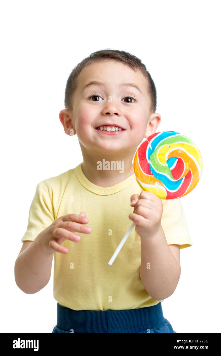 Glückliches Kind Junge essen große Süßigkeiten Lutscher auf weißem Hintergrund Stockfoto