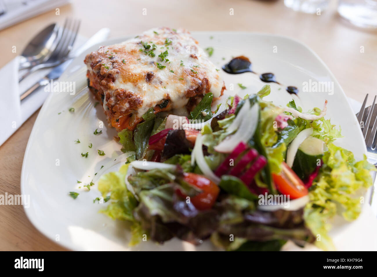 Authentische italienische Fleisch Lasagne mit frischer Salat. Stockfoto