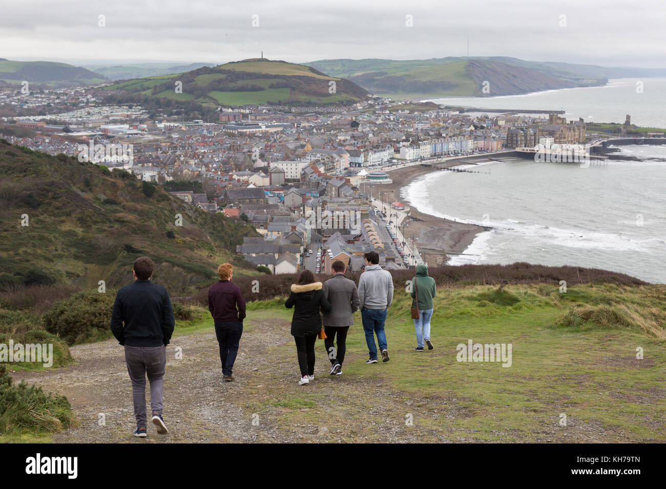 Gruppe von Jugendlichen herabsteigen Constitution Hill, Aberystwyth, Wales auf die Stadt und das Meer Stockfoto